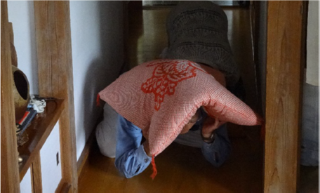 屋内で窓から離れて避難する住民の写真